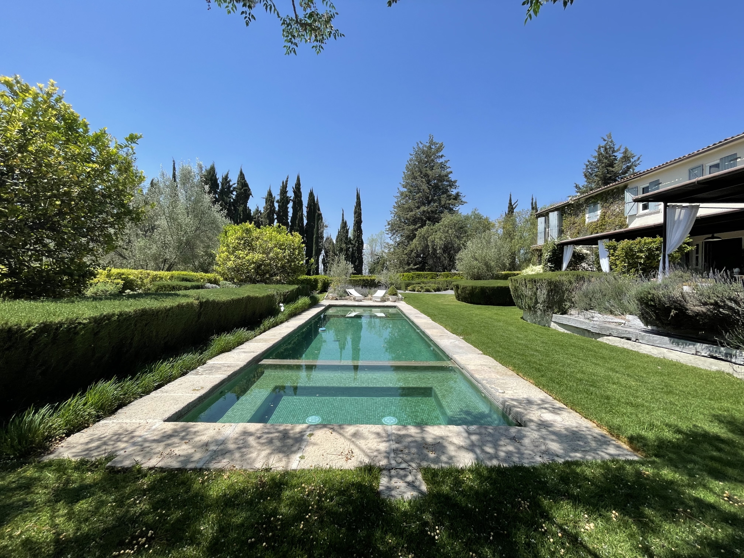 Luxury villa with private pool, surrounded by lush gardens and scenic landscape.