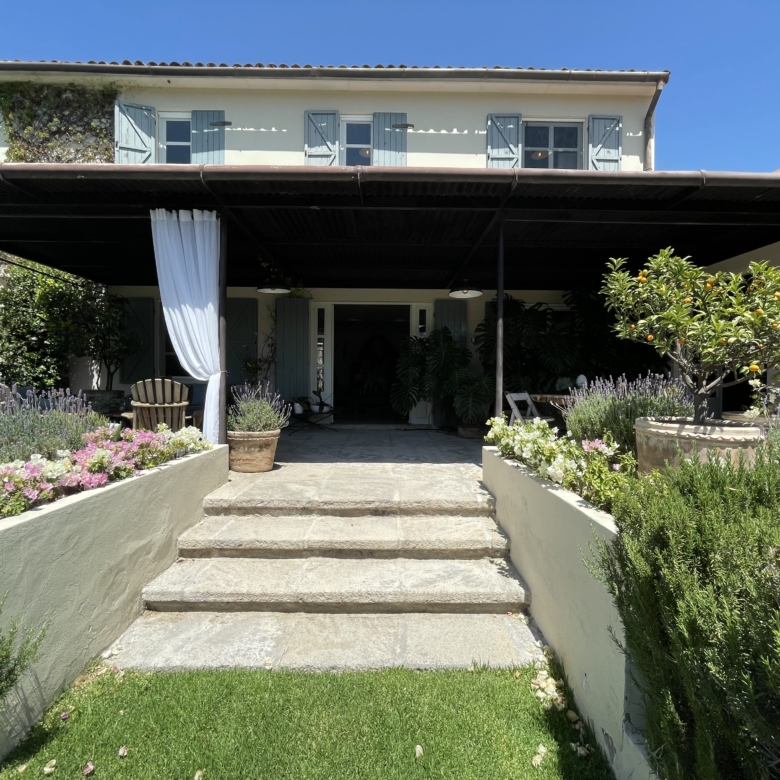 Modern garden entrance with steps and lush greenery.