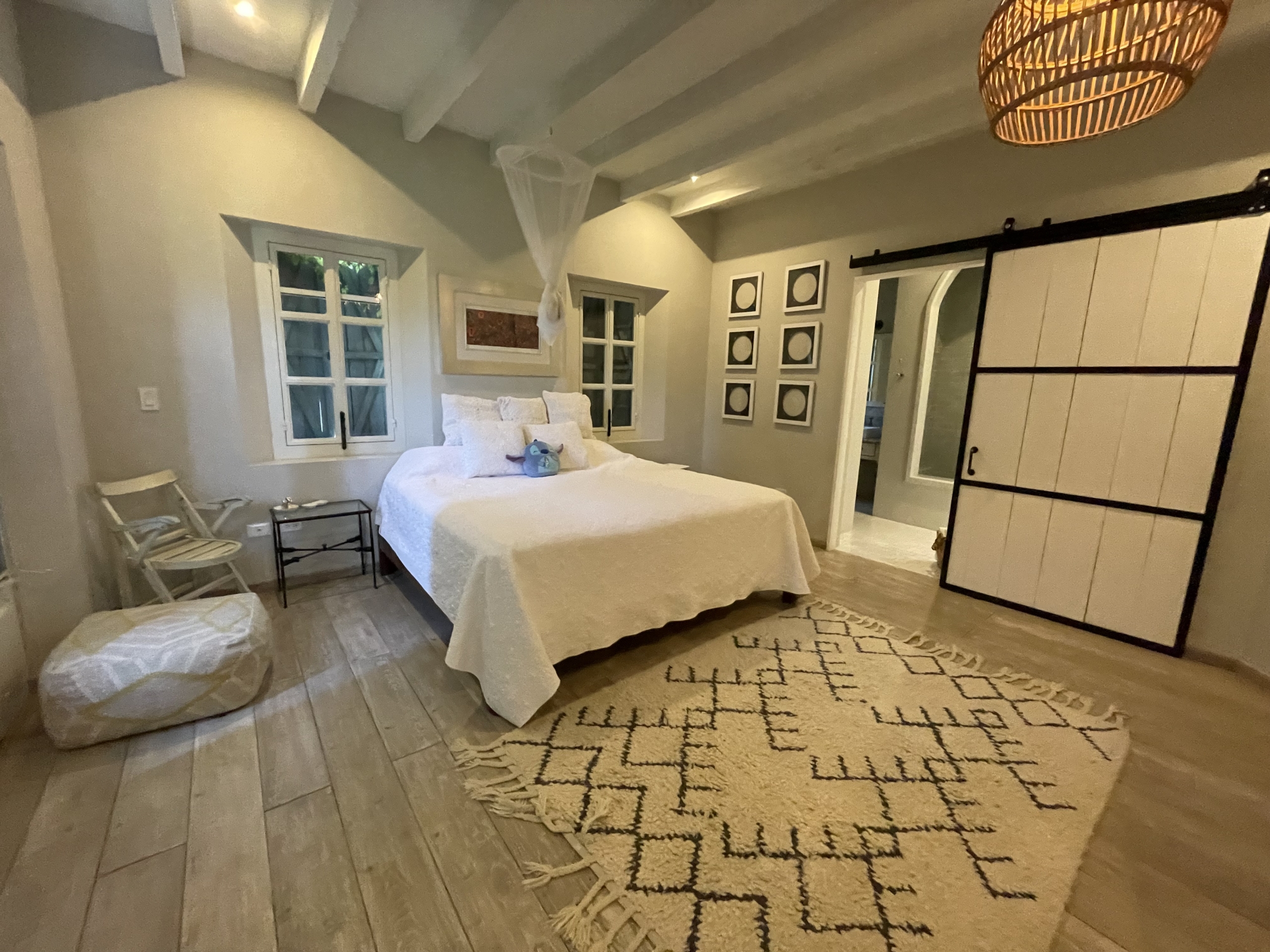 Spacious bedroom with white walls, wooden flooring, and stylish decor.