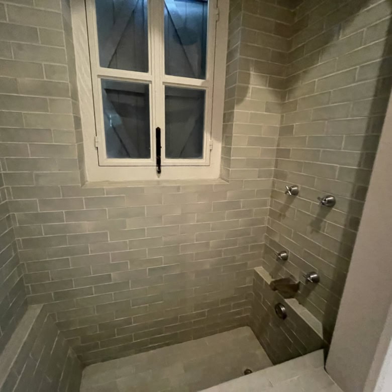 Home shower with window and gray brick tiles for a modern look.