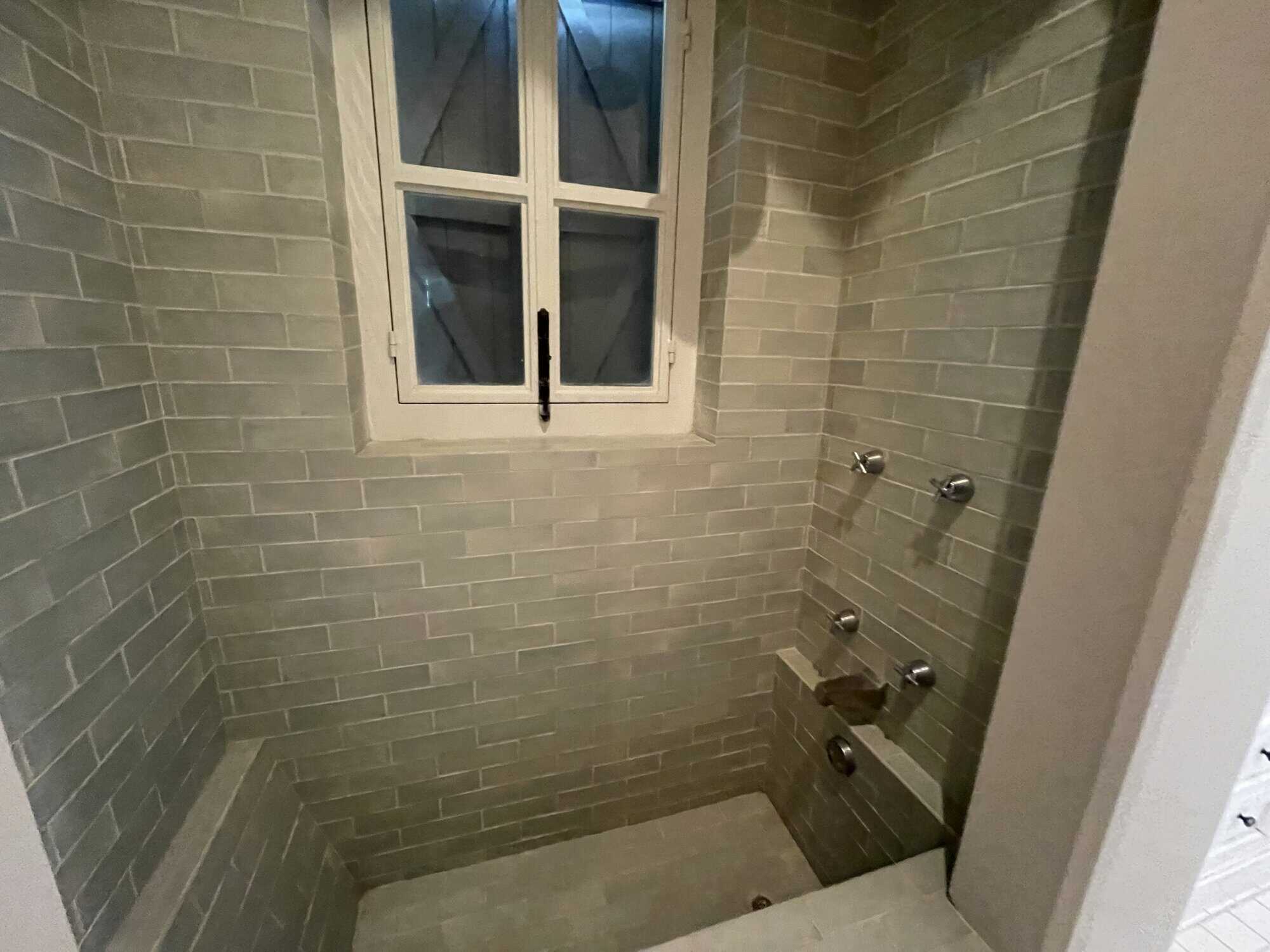 Home shower with window and gray brick tiles for a modern look.