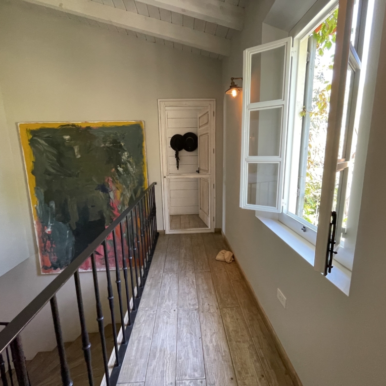 Bright room with open window and artwork on wall.