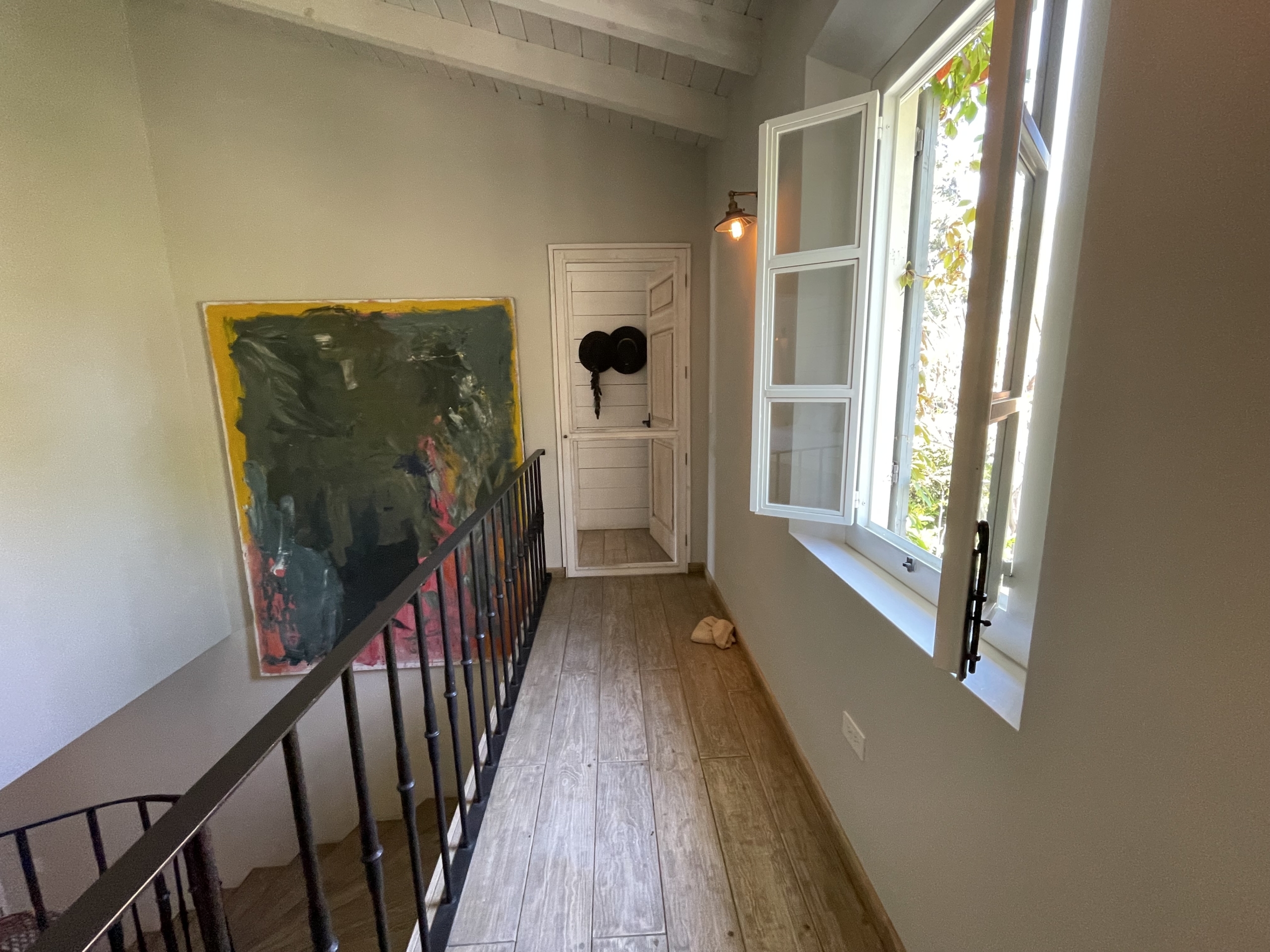 Bright room with open window and artwork on wall.