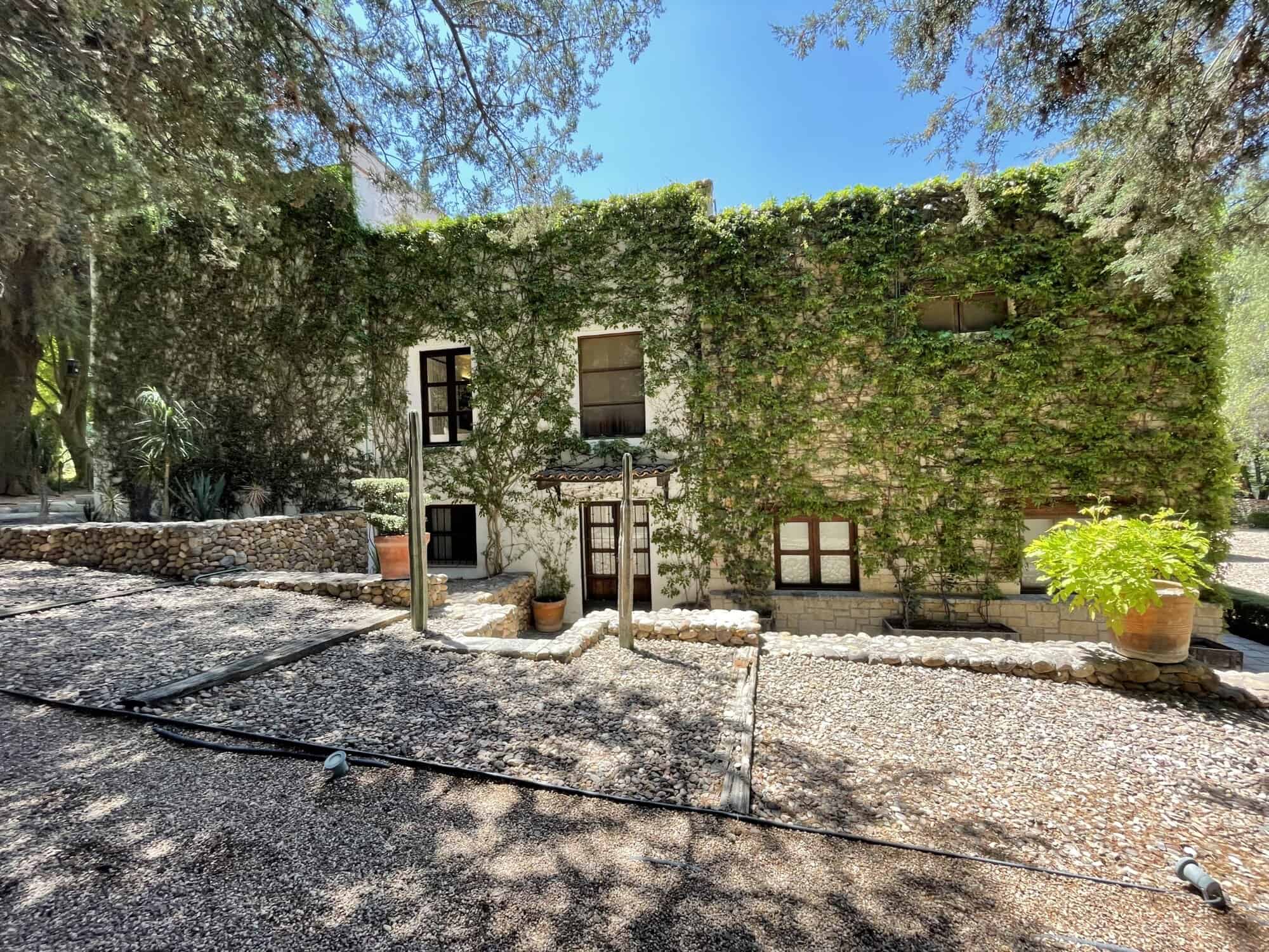 Ivy-covered historic house with lush greenery and rustic charm, perfect for a peaceful retreat or in.