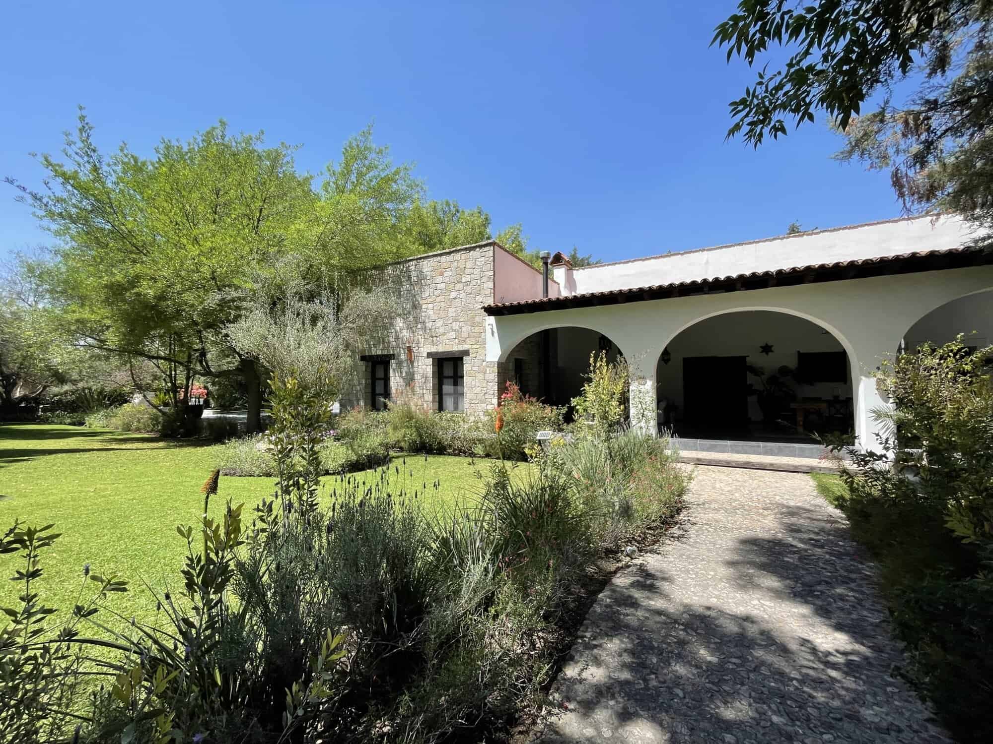 Charming country house with lush garden and shaded porch in Spain.