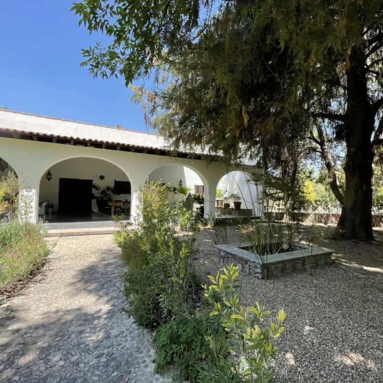 Spanish villa with garden, shaded patio, and outdoor seating area.