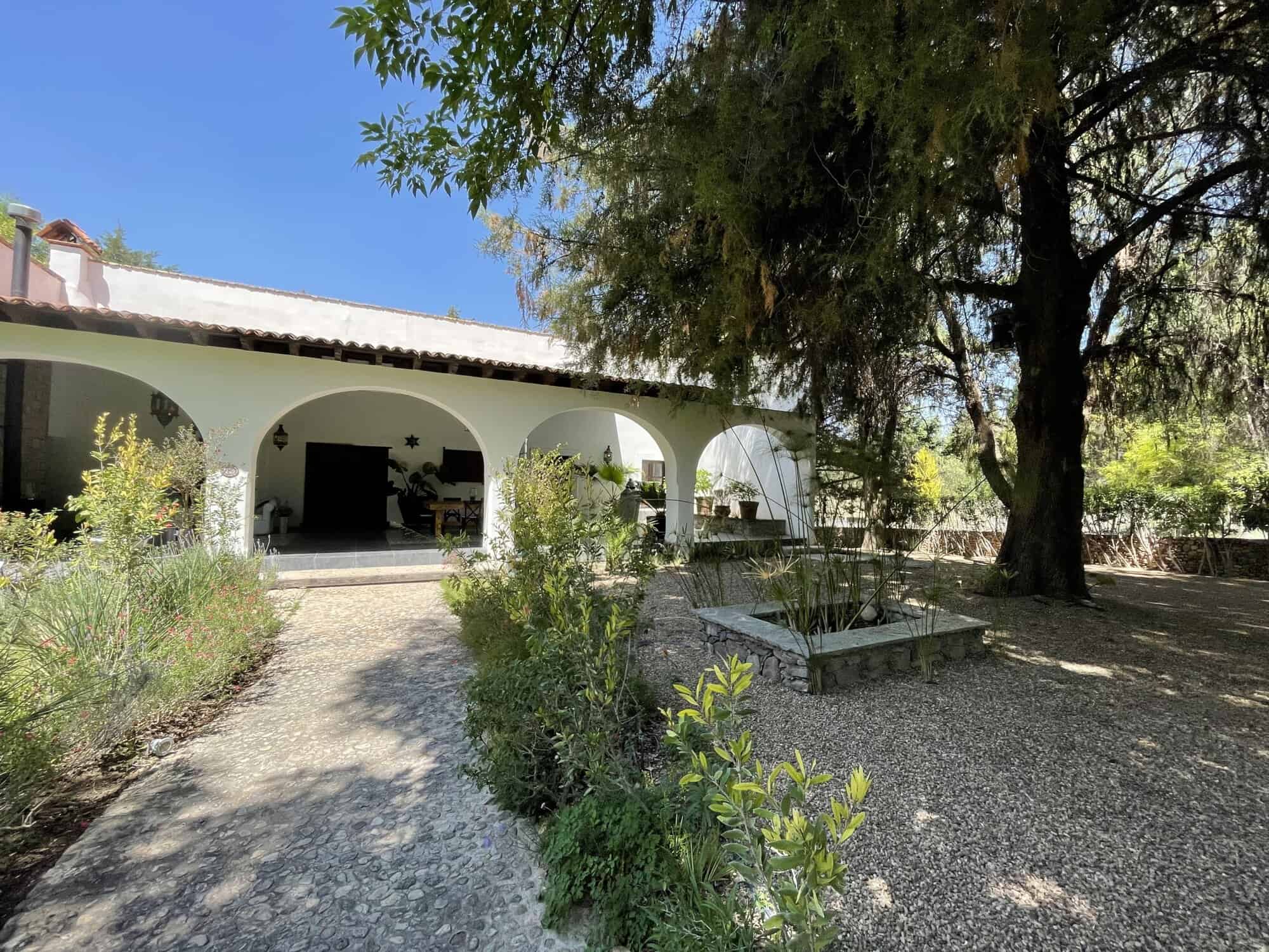 Spanish villa with garden, shaded patio, and outdoor seating area.