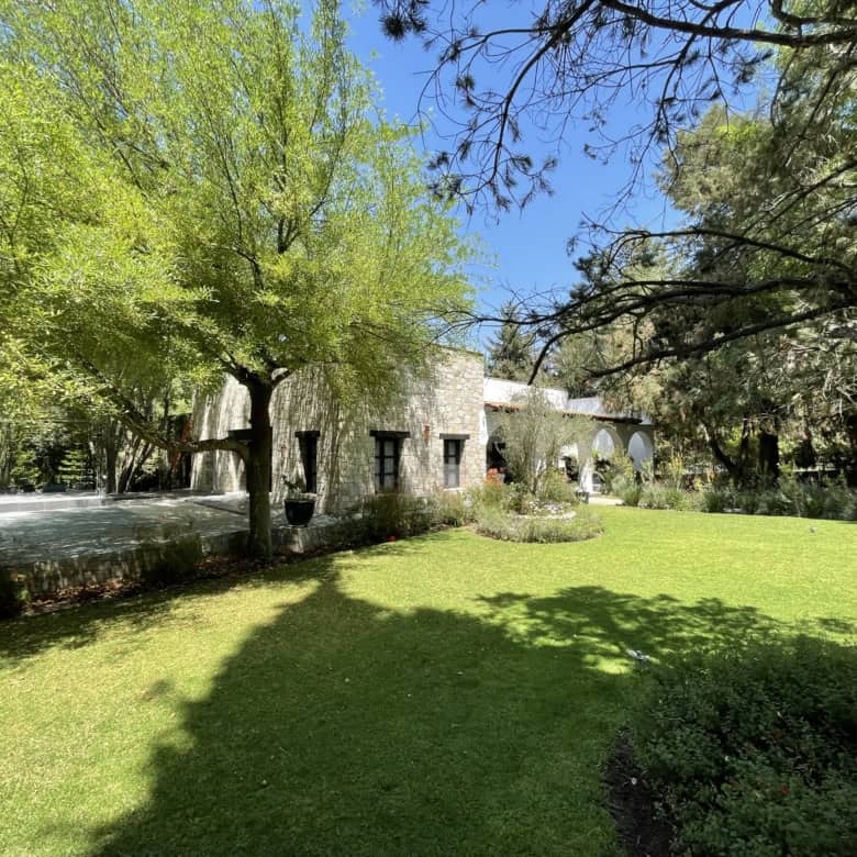 Beautiful countryside villa with expansive gardens and shaded areas for relaxation.