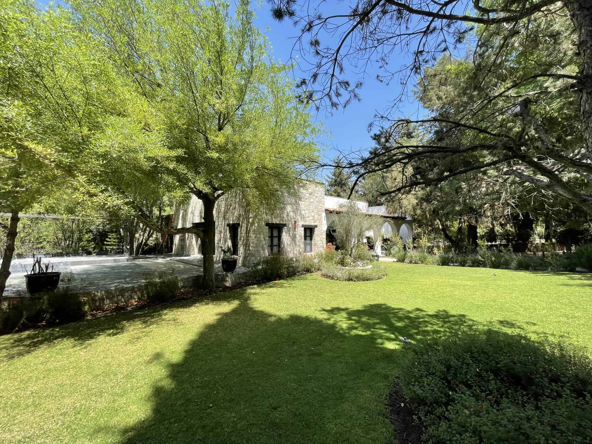 Beautiful countryside villa with expansive gardens and shaded areas for relaxation.
