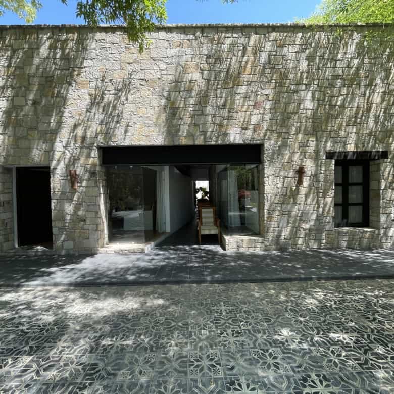 Modern stone villa with spacious entrance and garden views.