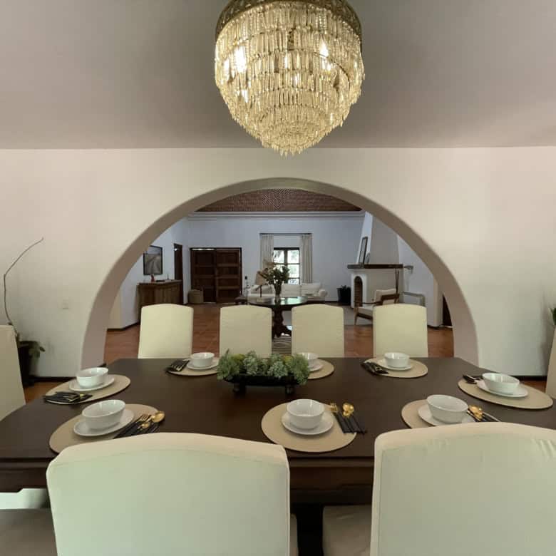Elegant dining room with a large chandelier and stylish decor.