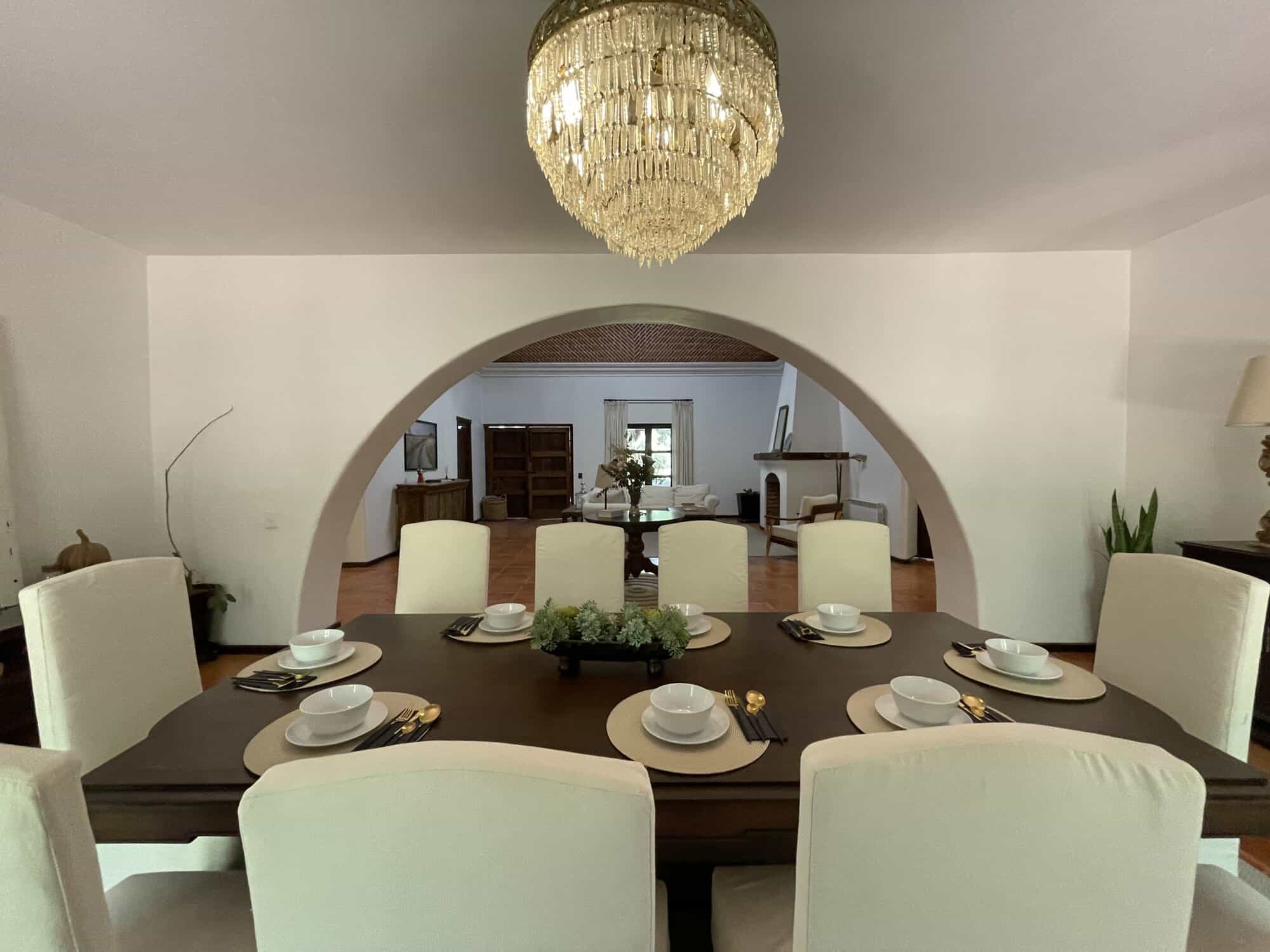 Elegant dining room with a large chandelier and stylish decor.
