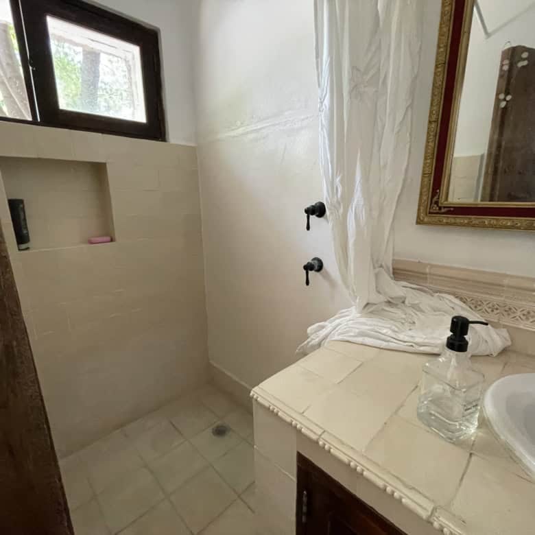 Modern bathroom with shower, vanity, and mirror in a property listing.