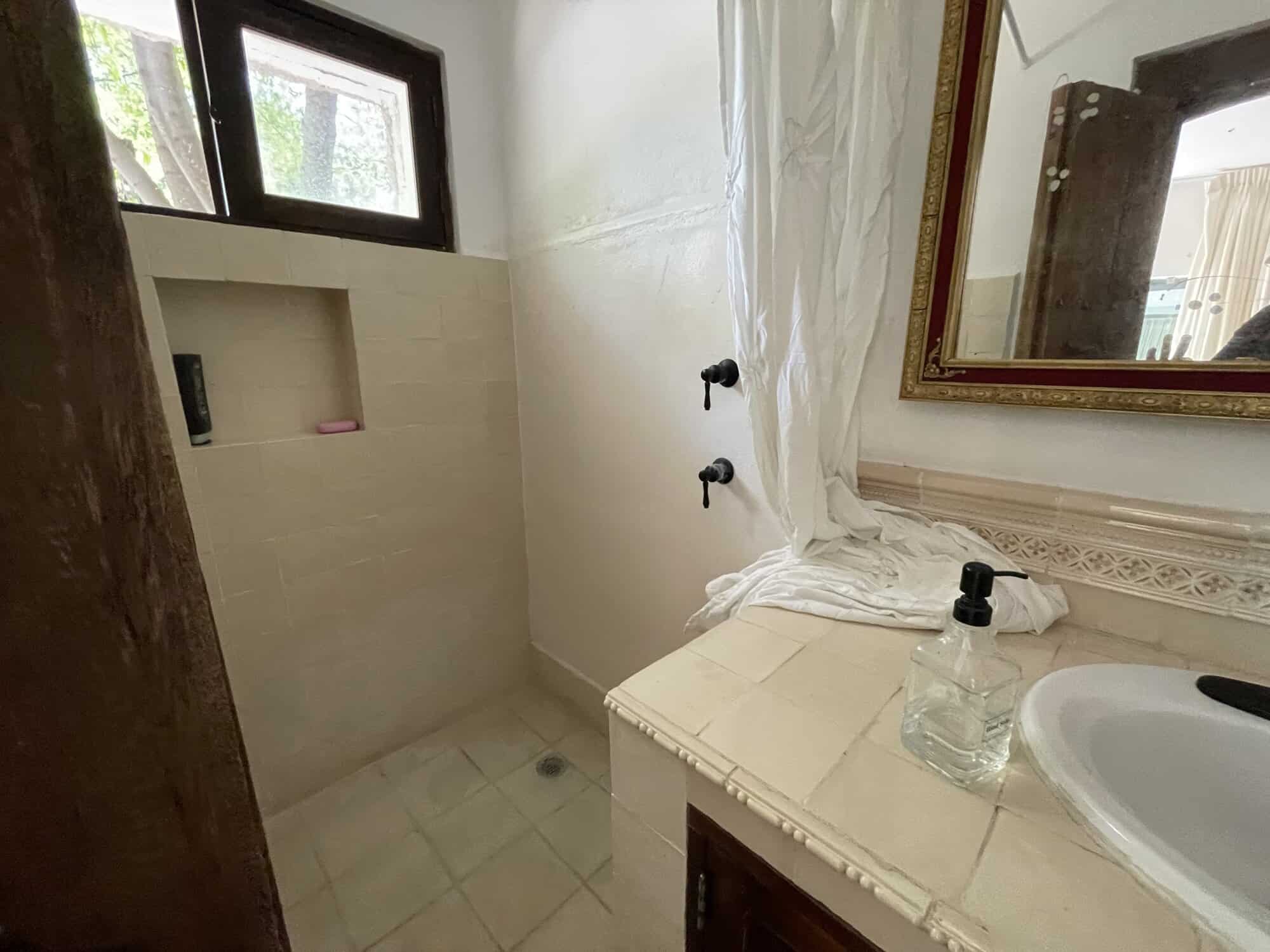 Modern bathroom with shower, vanity, and mirror in a property listing.