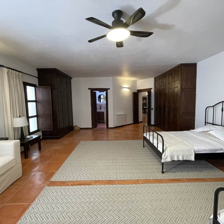 Bright and airy bedroom featuring a vintage iron bed and elegant wooden wardrobes. Perfect for comfo.