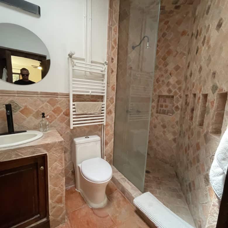 Bathroom with walk-in shower, toilet, and sink in a contemporary style.