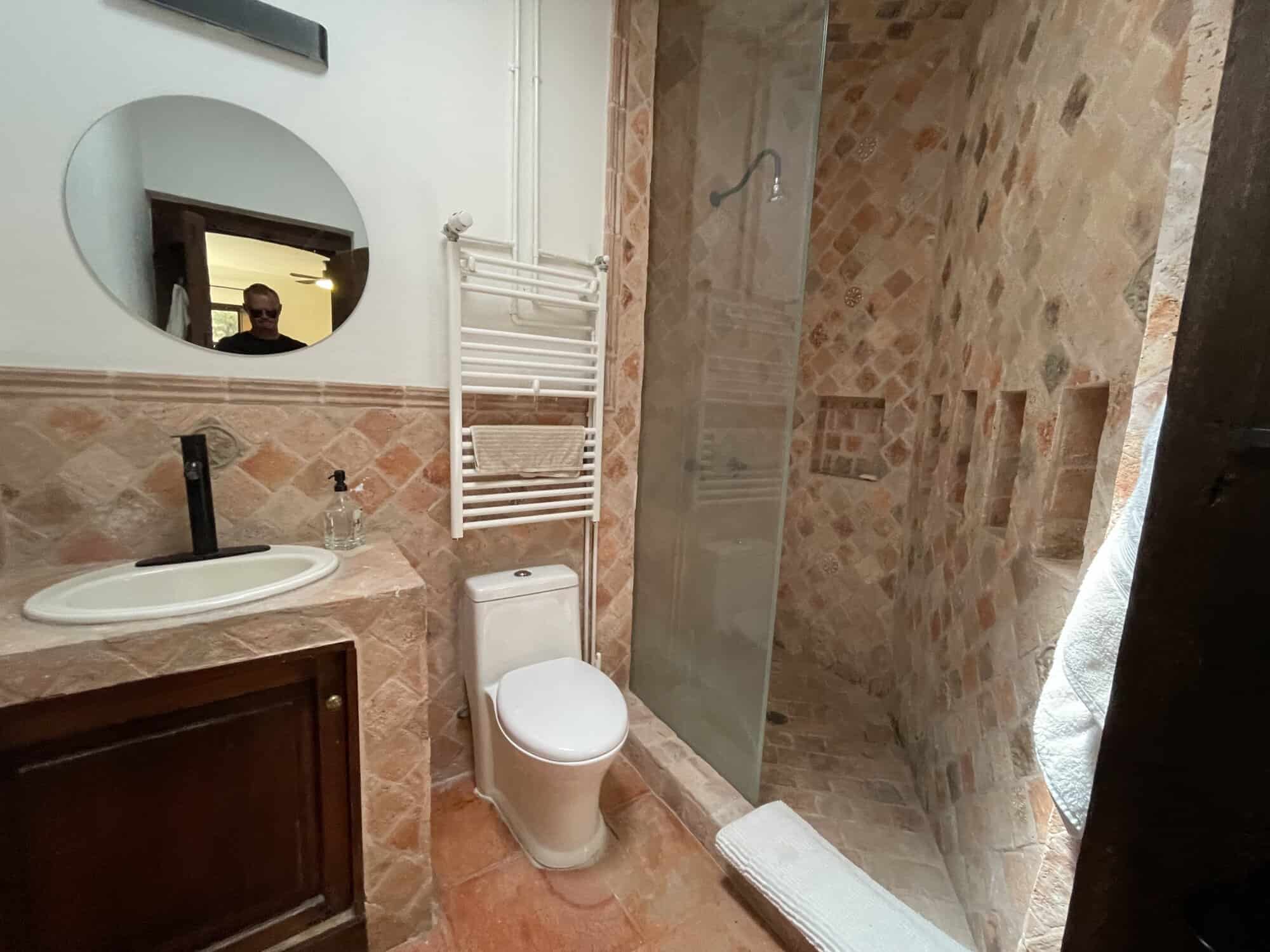 Bathroom with walk-in shower, toilet, and sink in a contemporary style.