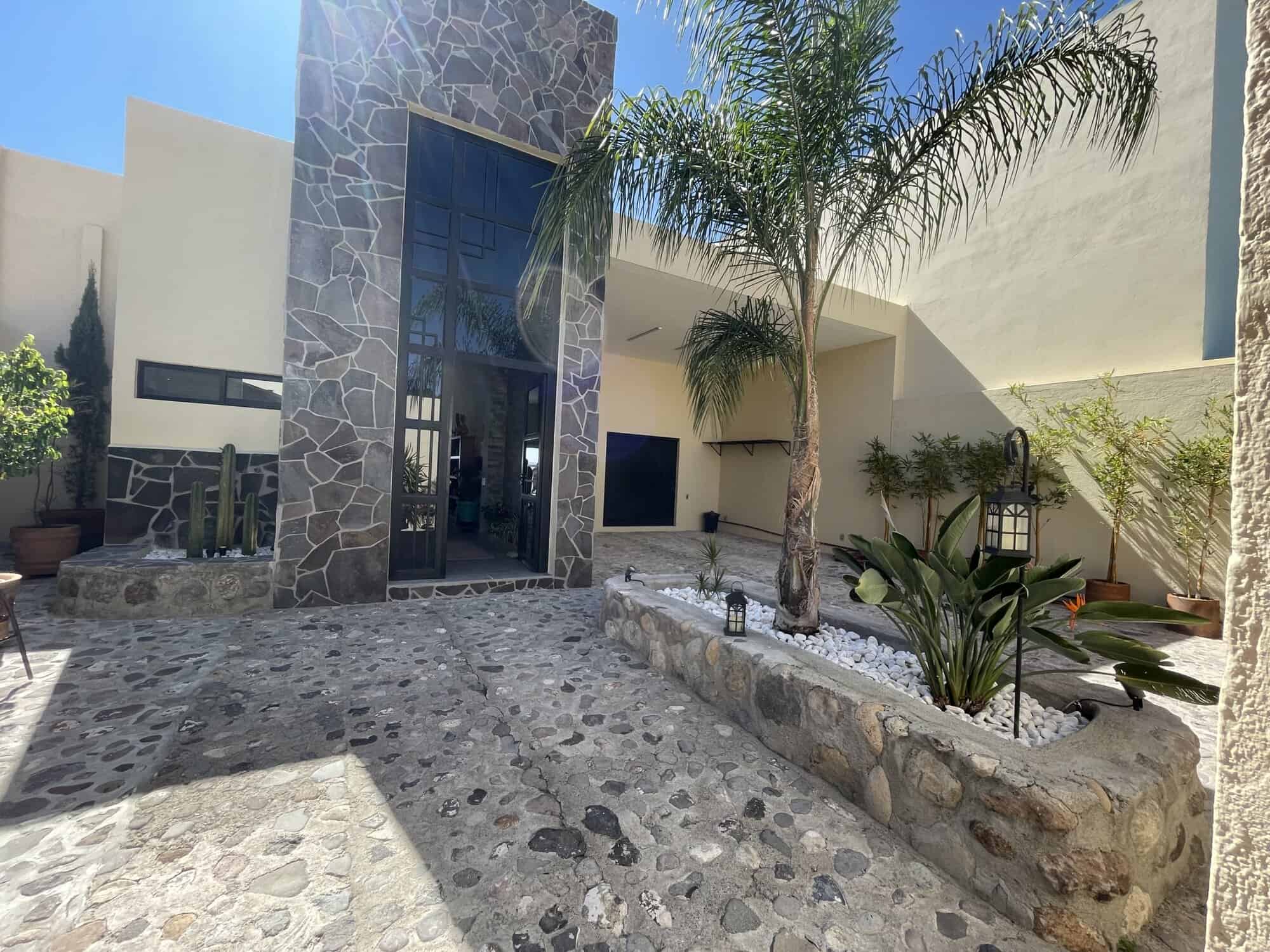 Modern villa with tropical garden, palm trees, and stylish exterior design.