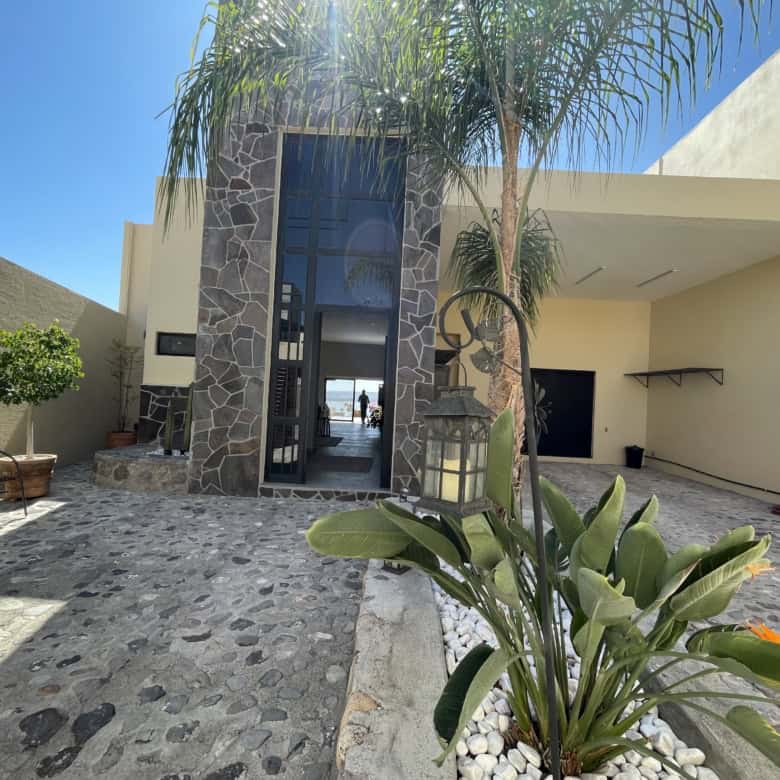 Luxury beachfront villa with tropical garden, pool, and modern architecture.