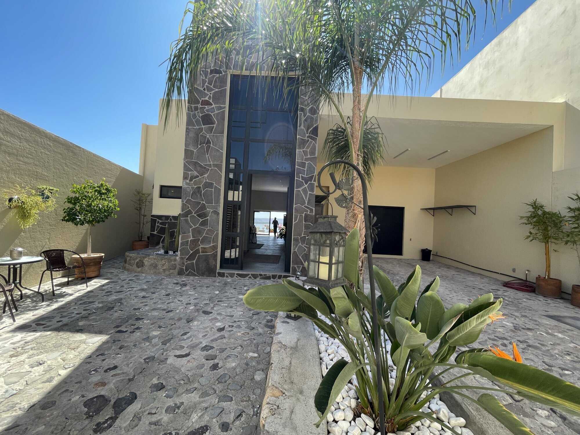 Luxury beachfront villa with tropical garden, pool, and modern architecture.