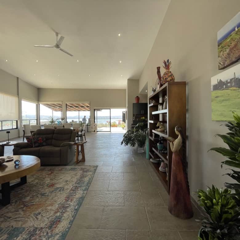 Modern living room with large windows and scenic views, featuring comfortable seating and stylish de.