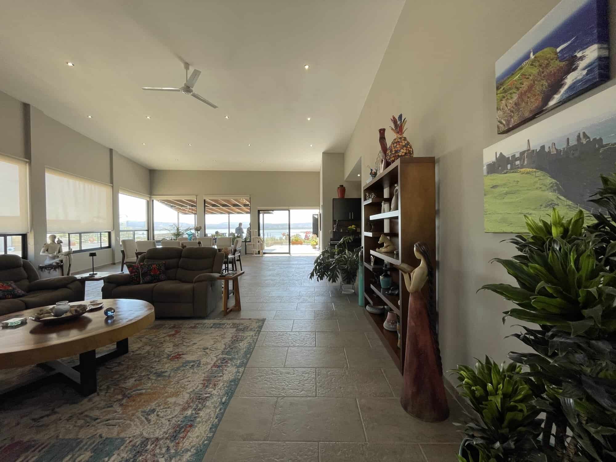 Modern living room with large windows and scenic views, featuring comfortable seating and stylish de.