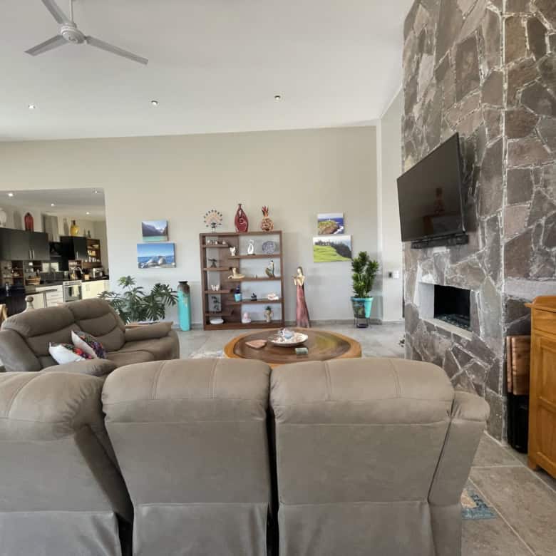 Spacious living room featuring a stone fireplace, comfortable sofas, and stylish decor for relaxing.
