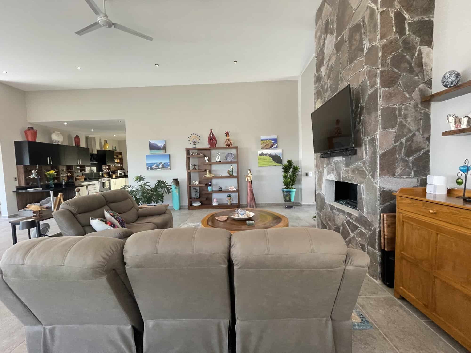 Spacious living room featuring a stone fireplace, comfortable sofas, and stylish decor for relaxing.