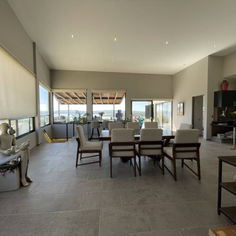 Spacious living room with large windows and balcony overlooking cityscape.