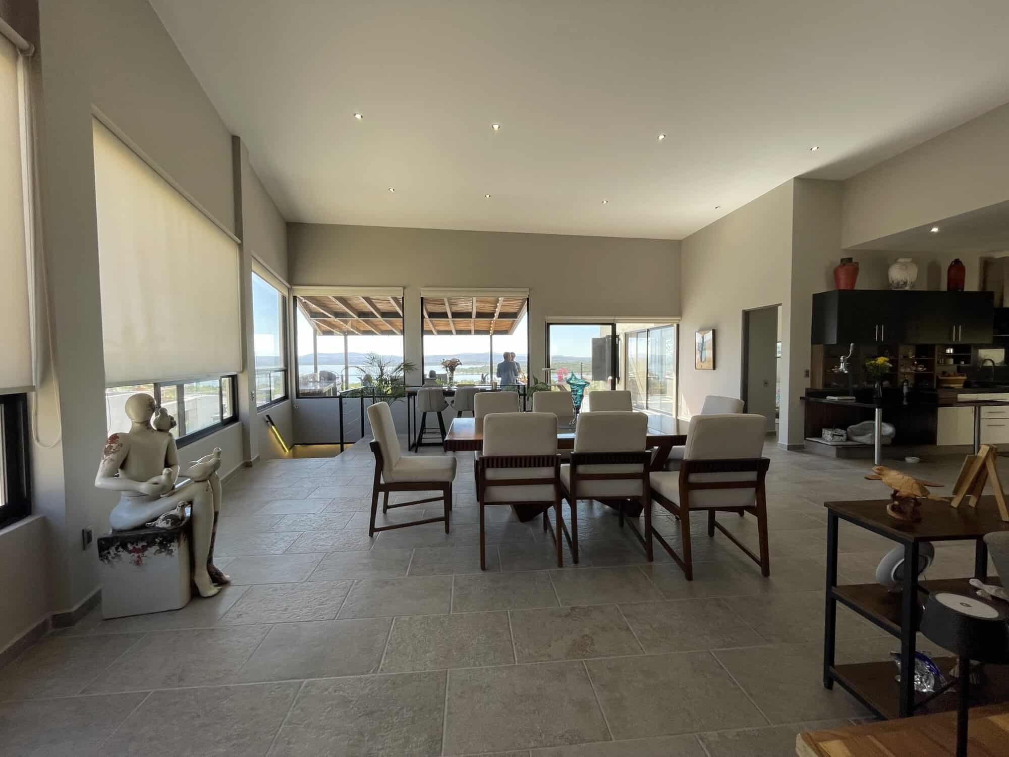 Spacious living room with large windows and balcony overlooking cityscape.