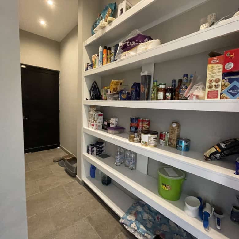 Home pantry with organized shelves of food, drinks, and household items.