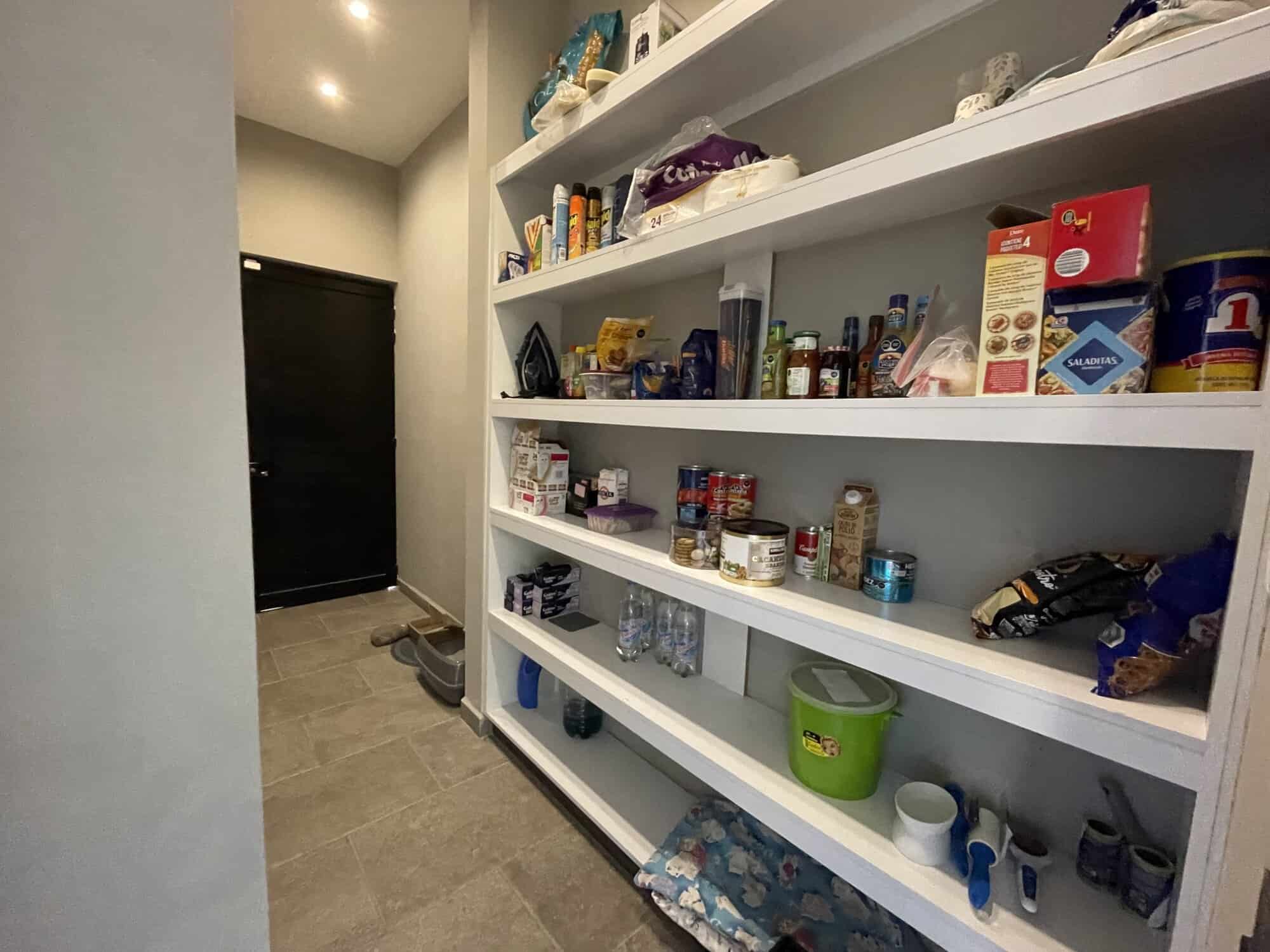 Home pantry with organized shelves of food, drinks, and household items.