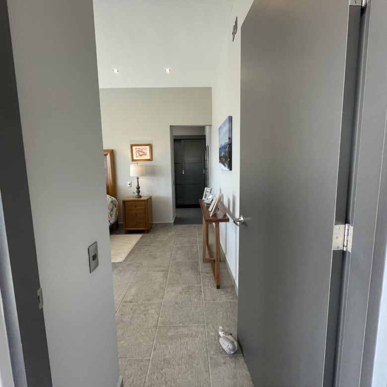 Interior view of a modern apartment hallway leading to living space and bedroom.