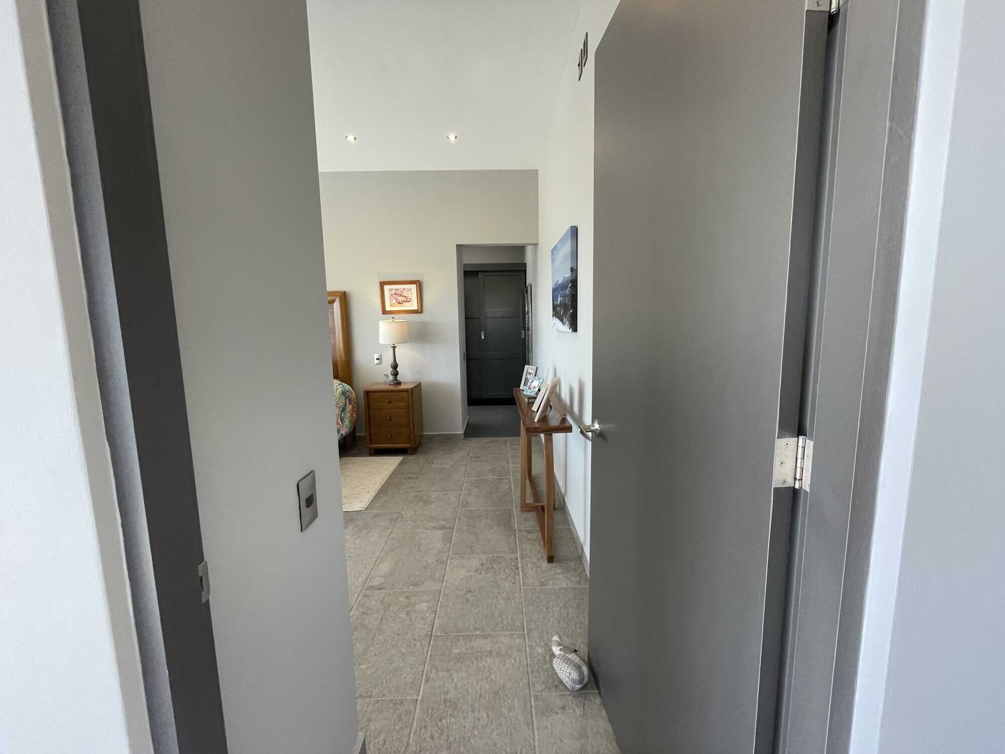 Interior view of a modern apartment hallway leading to living space and bedroom.