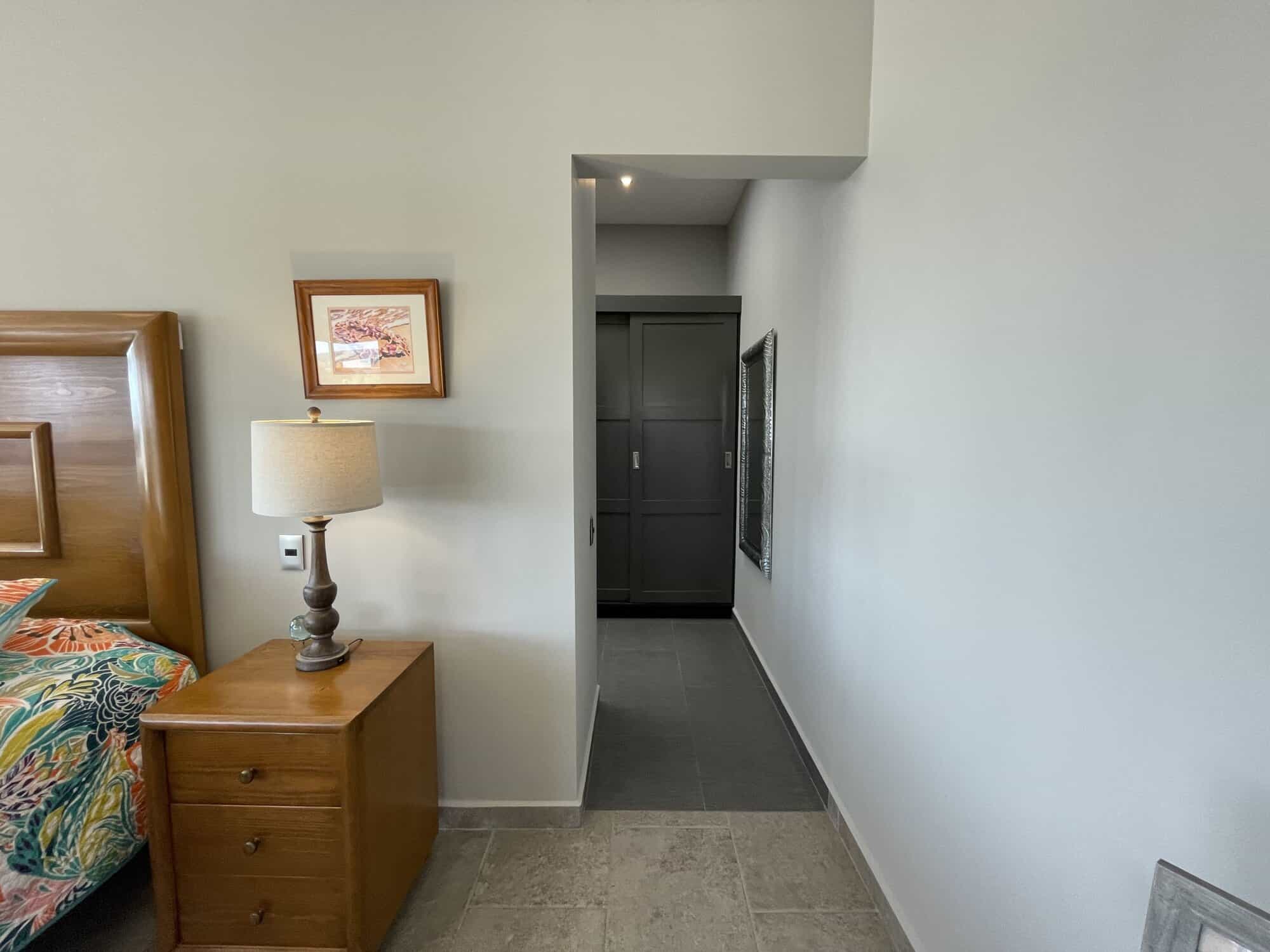 Modern bedroom with wooden furniture, nightstand, and artwork on the wall.