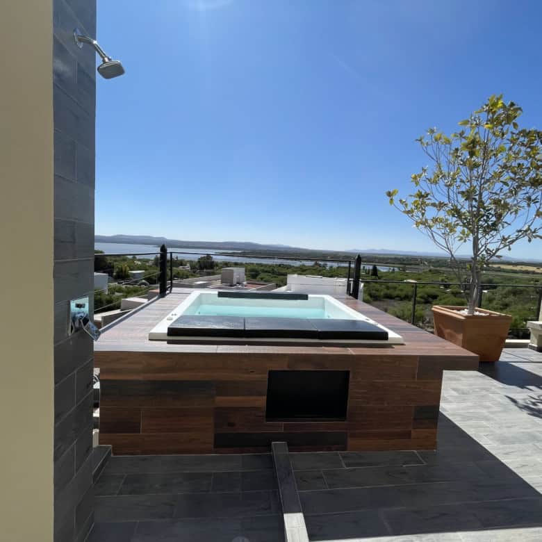Rooftop hot tub overlooking scenic landscape and city skyline.