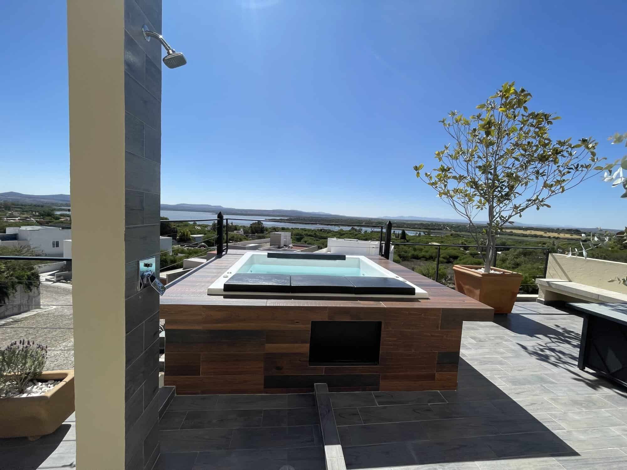 Rooftop hot tub overlooking scenic landscape and city skyline.