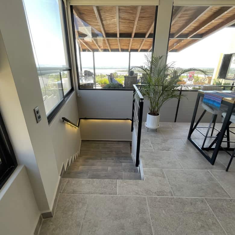 Balcony with large glass windows, outdoor seating, and scenic views, perfect for relaxing and enjoyi.