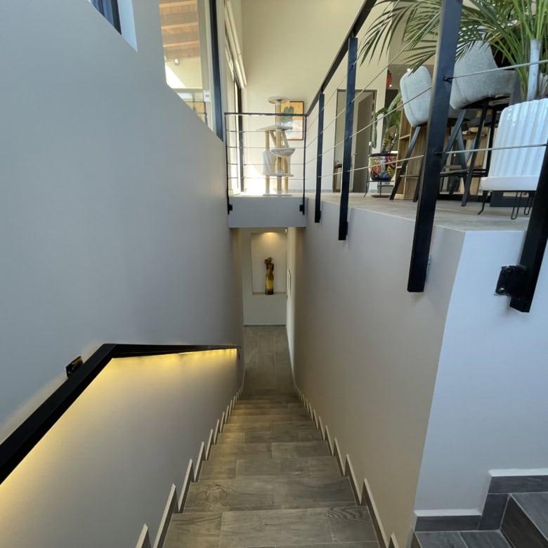 Stylish interior staircase leading to a modern home with contemporary decor and ambient lighting.