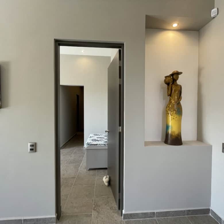 Modern minimalist interior with decorative sculpture and neutral color palette.