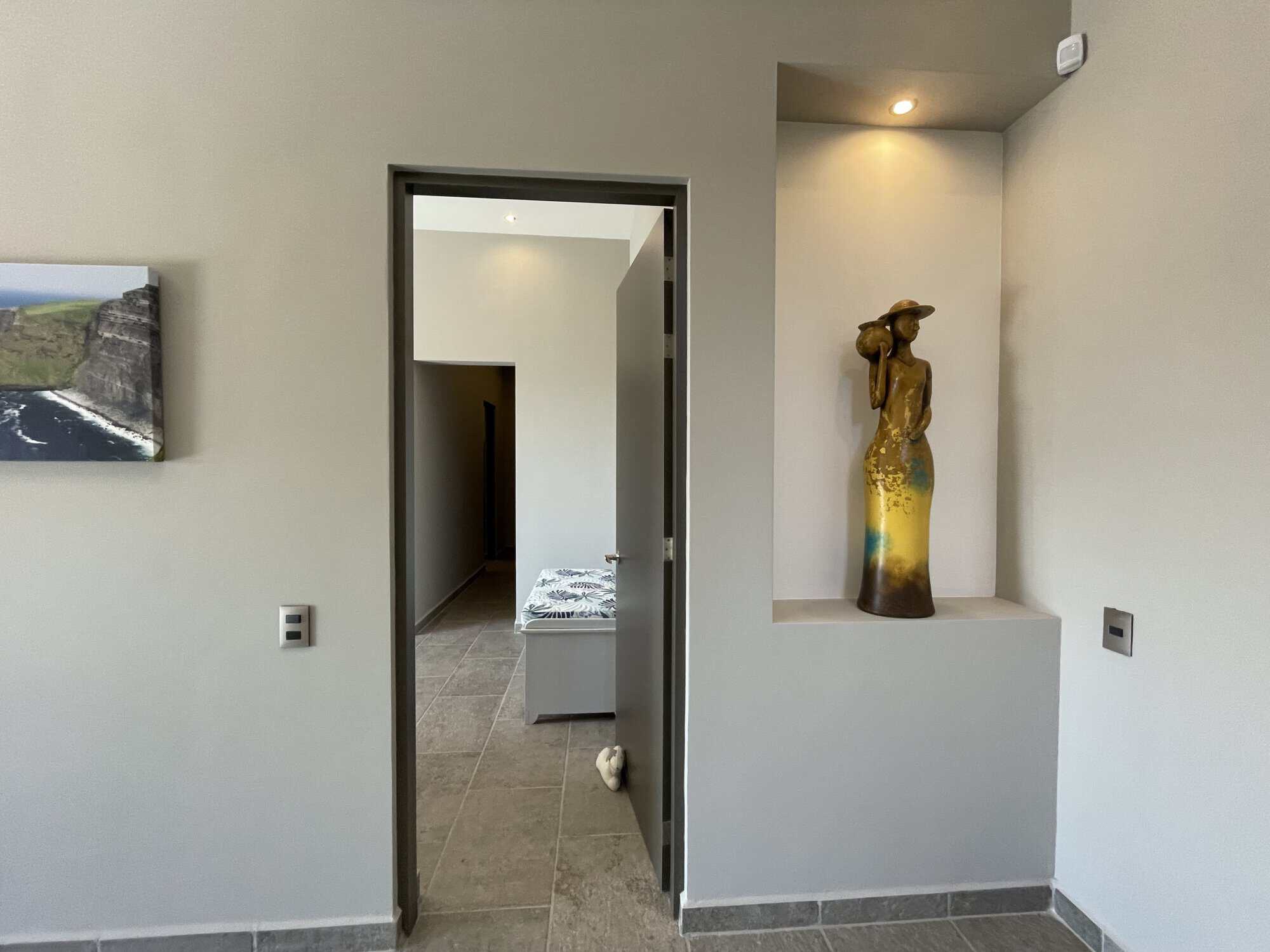 Modern minimalist interior with decorative sculpture and neutral color palette.