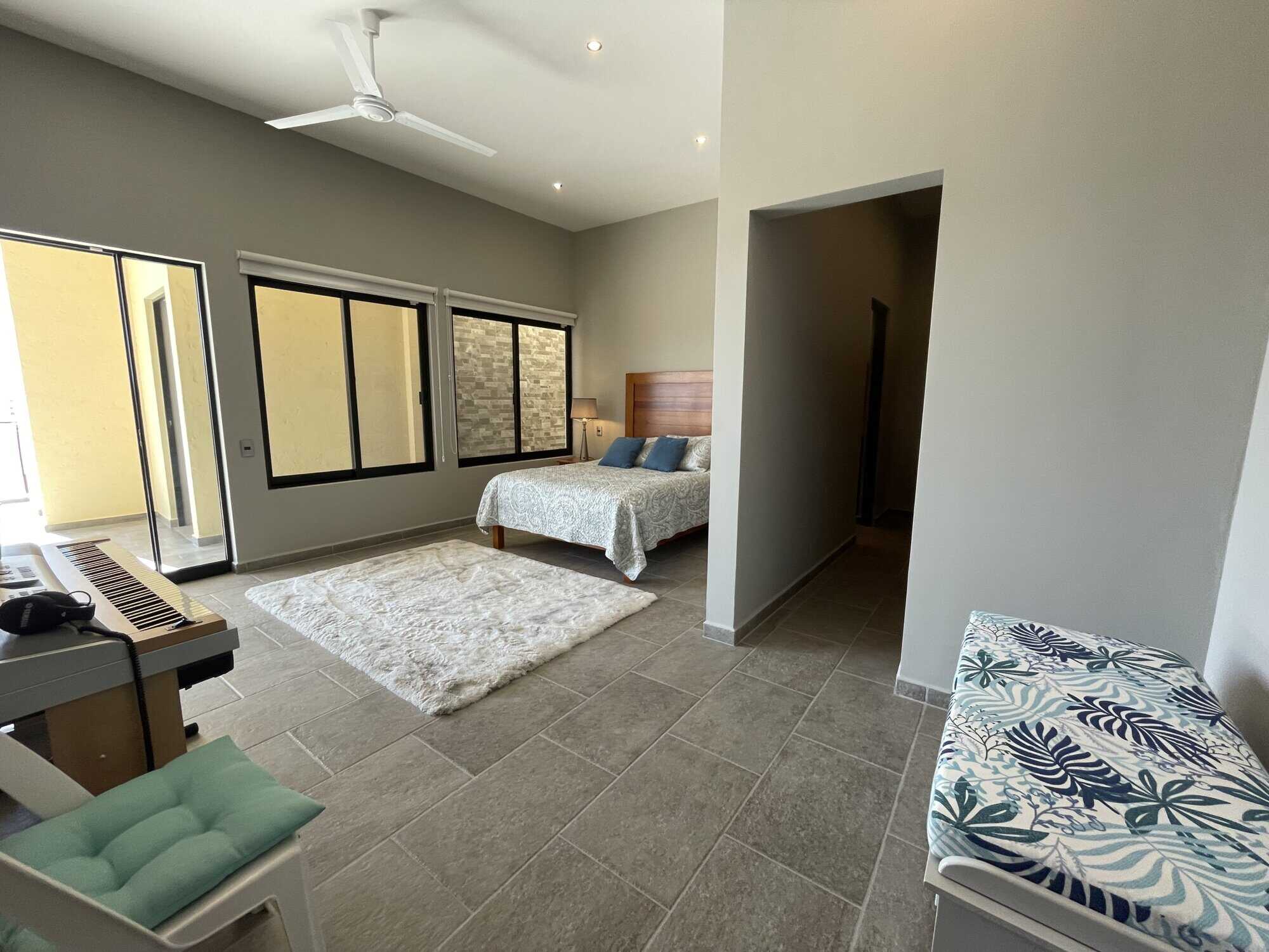 Spacious bedroom featuring large windows, balcony access, and contemporary decor for comfortable liv.