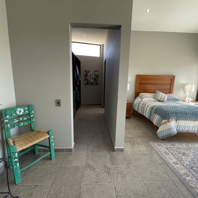 Spacious bedroom featuring a large window, wooden bed frame, and contemporary decor for a comfortabl.