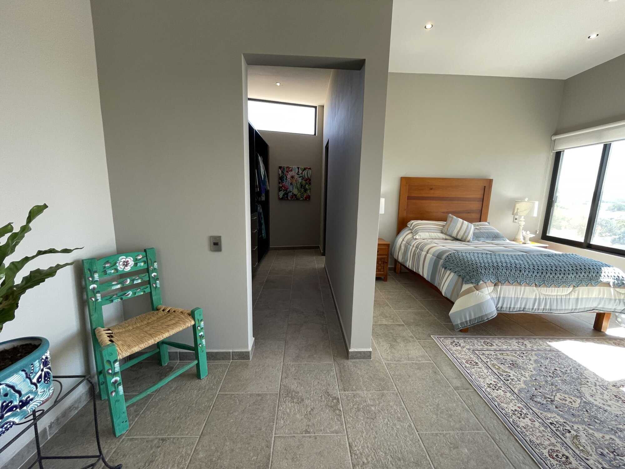 Spacious bedroom featuring a large window, wooden bed frame, and contemporary decor for a comfortabl.