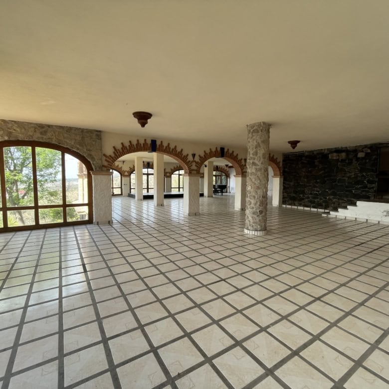 Spacious interior with large windows, tiled flooring, and stone accents, ideal for a luxurious home.