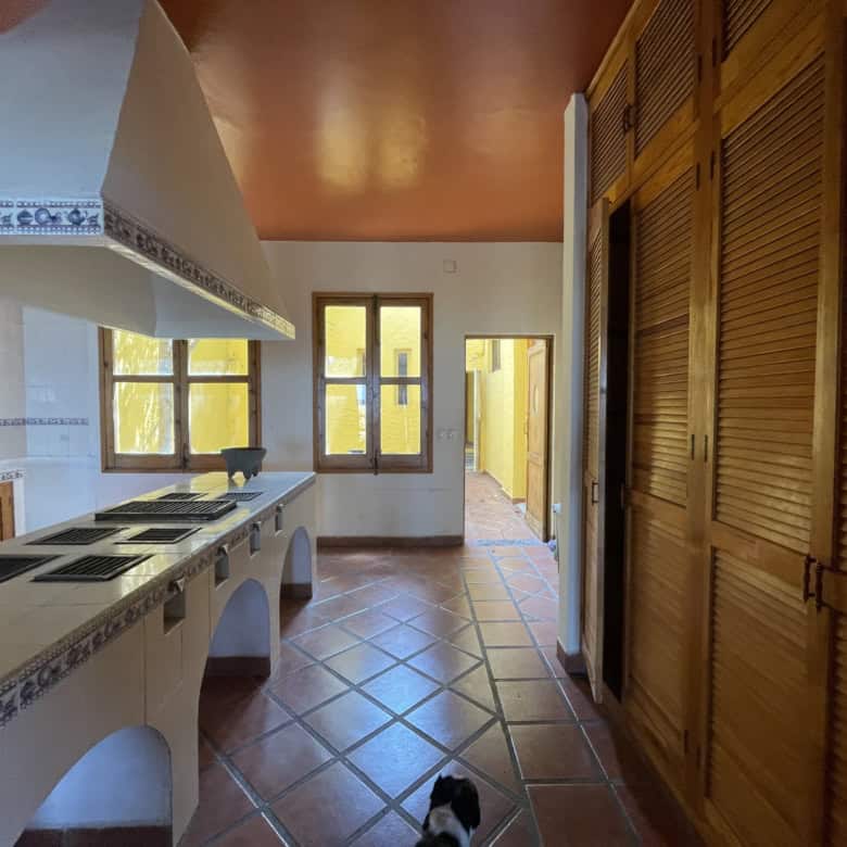 Warm kitchen with wooden cabinets and terracotta tiles.