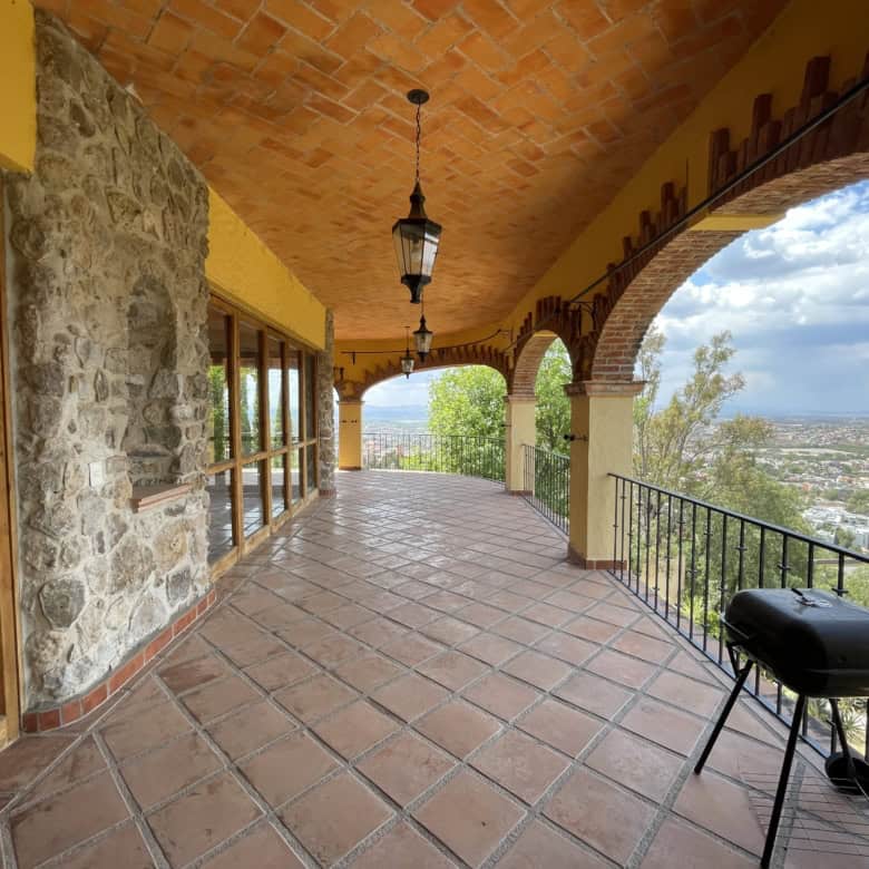 Luxury villa balcony overlooking scenic landscape and city views.