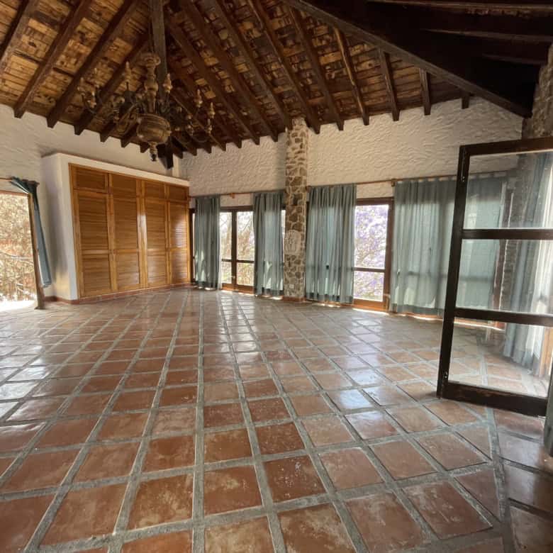 Bright and airy living space featuring terracotta tile flooring and expansive windows for natural li.