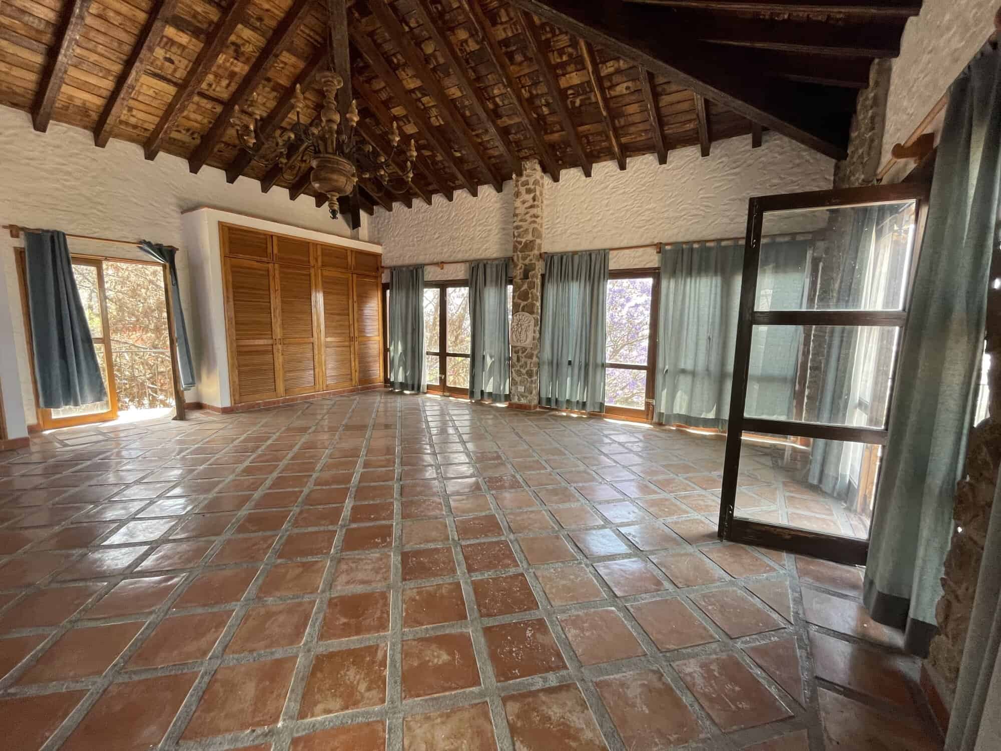 Bright and airy living space featuring terracotta tile flooring and expansive windows for natural li.