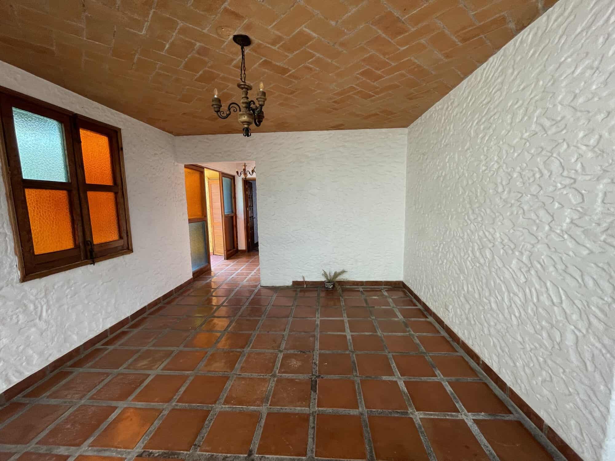 Traditional Spanish-style interior patio with terracotta tiles and colorful stained glass windows.